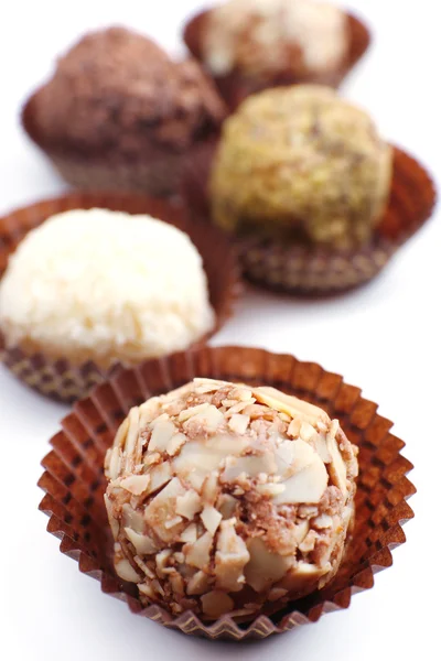 Süße runde Bonbons in Papierschüssel auf weißem Hintergrund gewickelt — Stockfoto