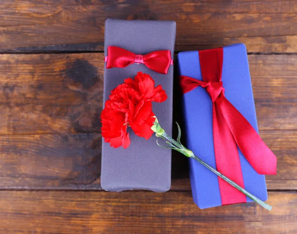 Dos cajas de regalo con clavel rojo sobre fondo de madera —  Fotos de Stock