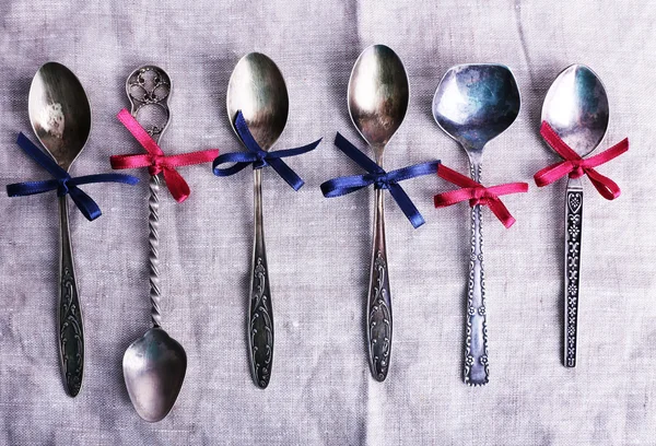 Metal spoons on white fabric background — Stock Photo, Image