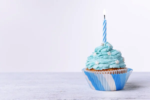 Delizioso cupcake di compleanno sul tavolo su sfondo bianco — Foto Stock