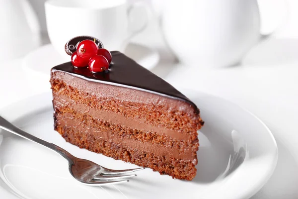 Delicious chocolate cake on plate on table on light background — Stok Foto
