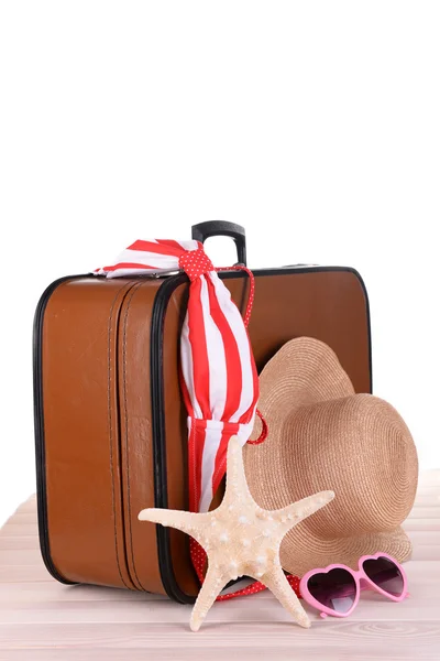 Винтажный чемодан с летними принадлежностями на деревянной доске — стоковое фото