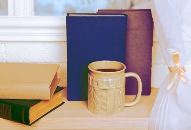 Kitap ve pencere üzerinde kahve