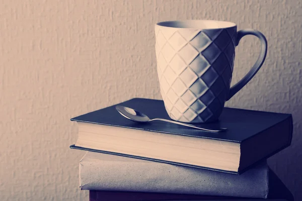 Старые книги и чашка кофе на столе — стоковое фото