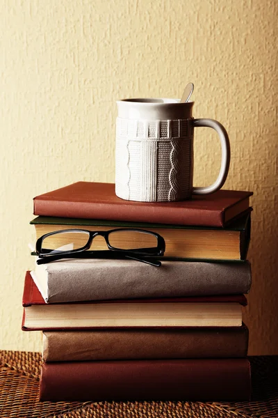 Oude boeken en kopje koffie op tabel — Stockfoto