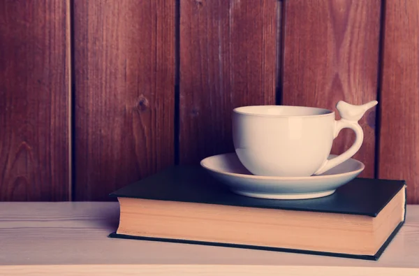 Livros antigos e xícara de café na mesa — Fotografia de Stock