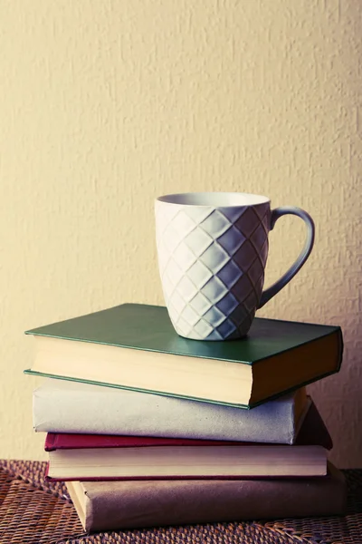 Oude boeken en kopje koffie op tabel — Stockfoto