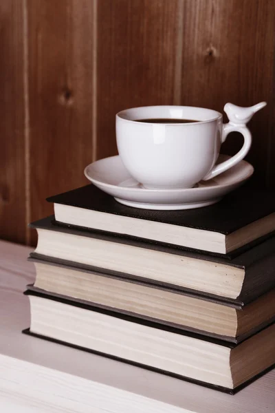 Old books and cup of coffee on table — Stock Photo, Image