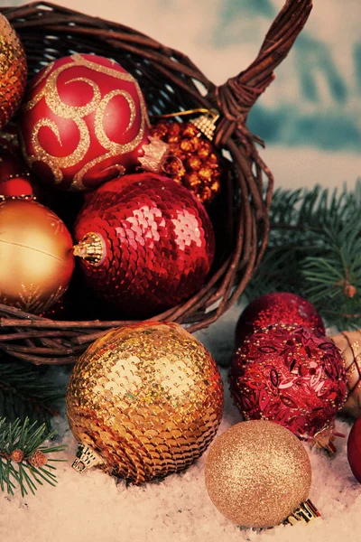 Decoraciones navideñas en cesta con nieve sobre mesa sobre fondo brillante —  Fotos de Stock