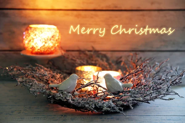 Christmas wreath with candles and decorative birds on wooden table — Stock Photo, Image