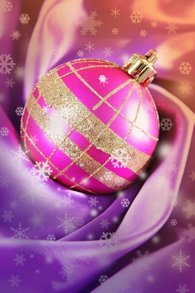 Beautiful Christmas ball on satin cloth, close-up — Stock Photo, Image