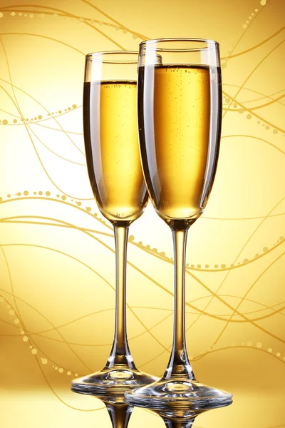 Glasses of champagne on yellow background — Stock Photo, Image