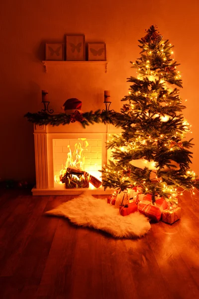 Kerstboom in de buurt van open haard in kamer — Stockfoto