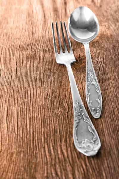 Cuchara y tenedor sobre fondo de madera — Foto de Stock