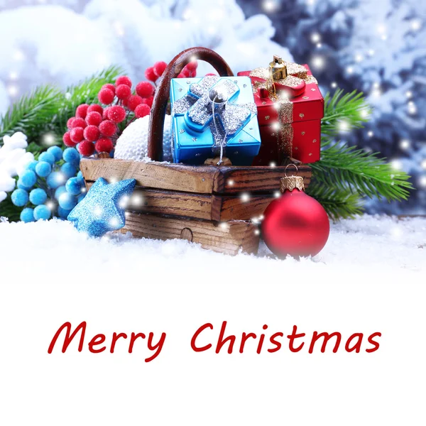 Состав с рождественскими украшениями в корзине и елкой на светлом фоне — стоковое фото