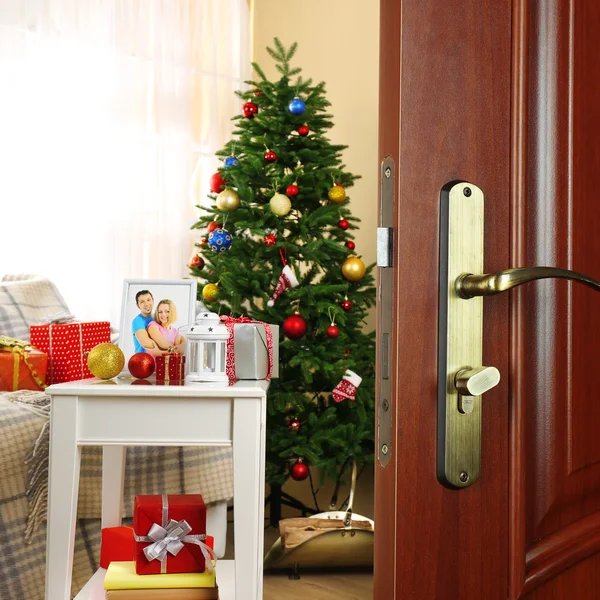 Porte ouverte avec arbre de Noël décoré dans la chambre Photos De Stock Libres De Droits
