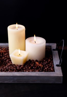 vintage tepsi ile kahve taneleri ve baharatlar koyu arka plan üzerinde ahşap masa üstünde mumlar
