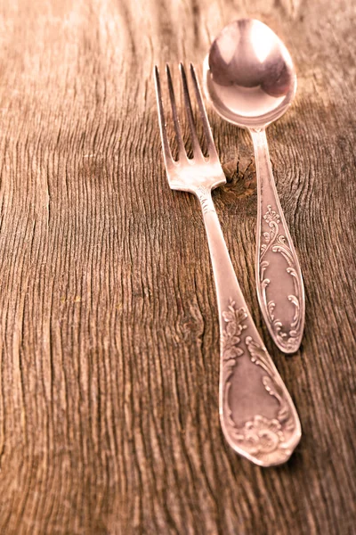 Lepel en vork op houten achtergrond — Stockfoto