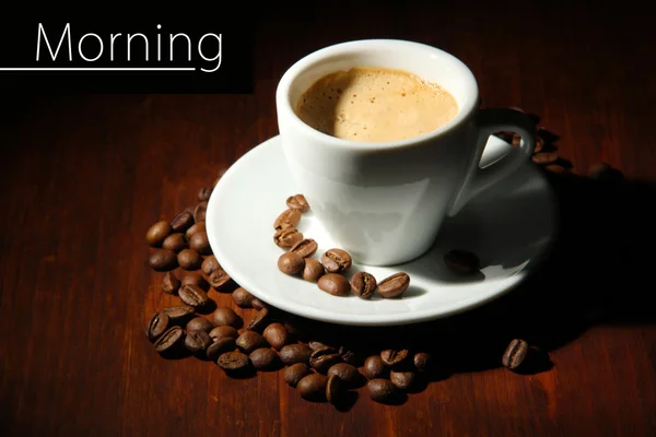 Kopp kaffe med kaffebönor på trä bakgrund — Stockfoto