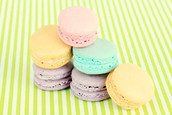 Macarons savoureux sur fond rayé vert — Photo