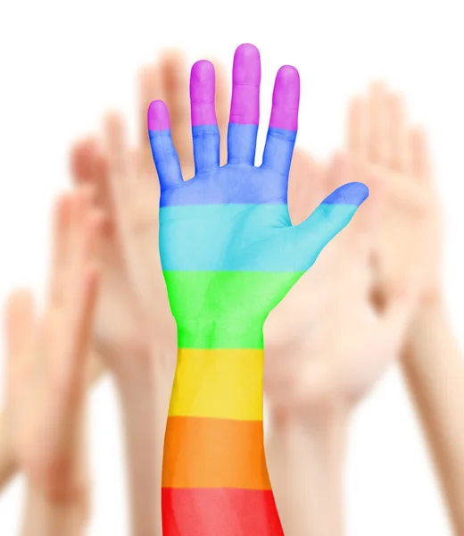 La mano dell'uomo dipinta come bandiera arcobaleno su sfondo altre mani — Foto Stock
