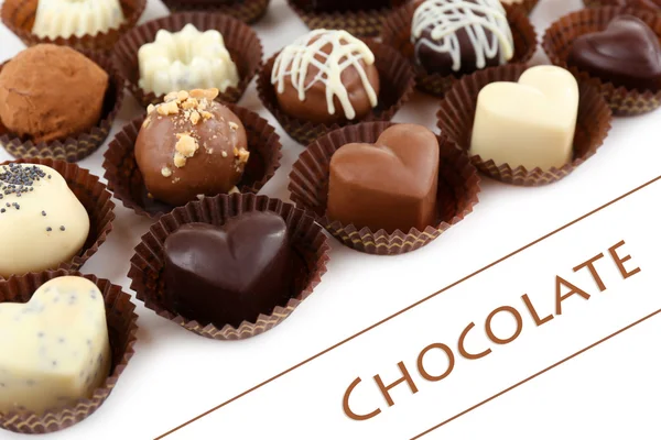 Beyaz arka planda lezzetli çikolata şekerleri — Stok fotoğraf