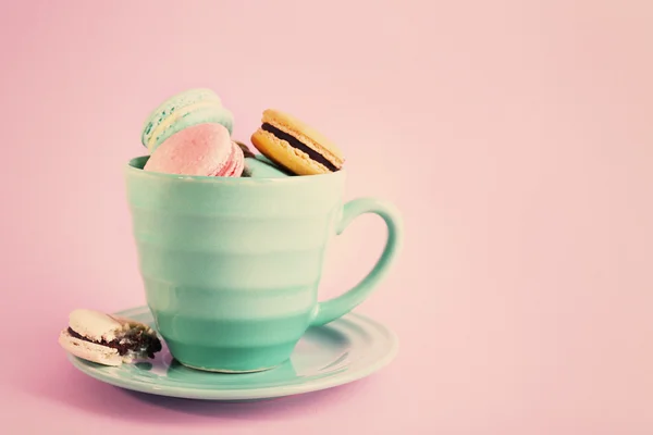 Assortment of gentle colorful macaroons in mug on pink background — Stock Photo, Image