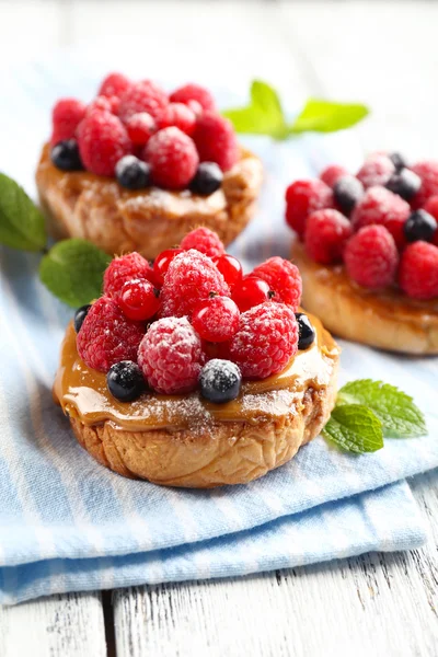 Süße Kuchen mit Beeren auf dem Tisch in Großaufnahme — Stockfoto