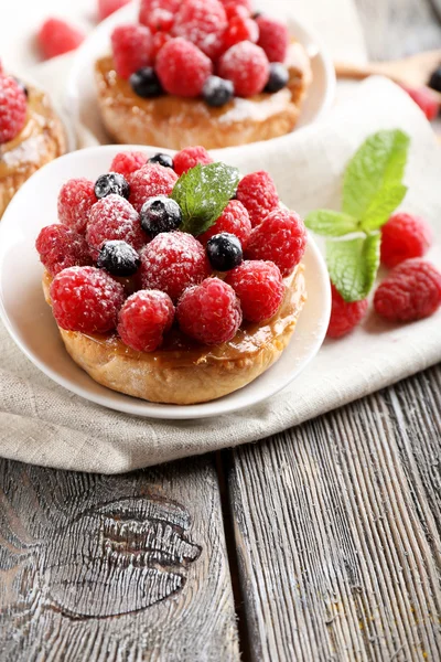 Süße Kuchen mit Beeren auf dem Tisch in Großaufnahme — Stockfoto