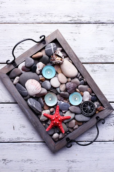 Świece na rocznika taca z morza Kamyczki, muszle rozgwiazdy i morze na drewniane tła — Zdjęcie stockowe