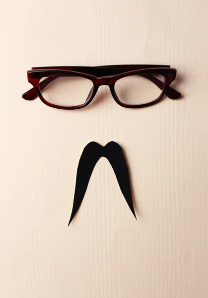 Lunettes et moustache formant le visage de l'homme sur fond beige — Photo