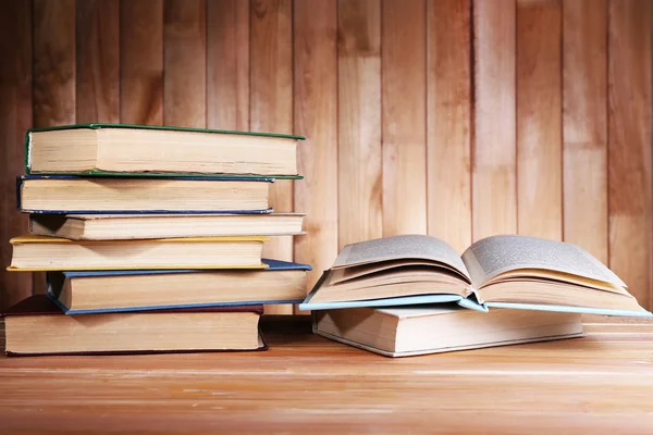 Libros sobre mesa de madera sobre fondo de pared de madera — Foto de Stock