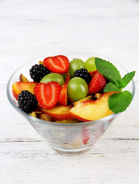 Frischer, schmackhafter Obstsalat auf Holztisch — Stockfoto