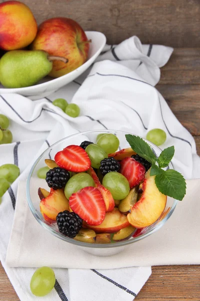 Chutné ovoce salát na dřevěný stůl — Stock fotografie