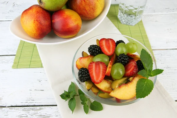 Świeże owoce smaczne sałatki na drewnianym stole — Zdjęcie stockowe