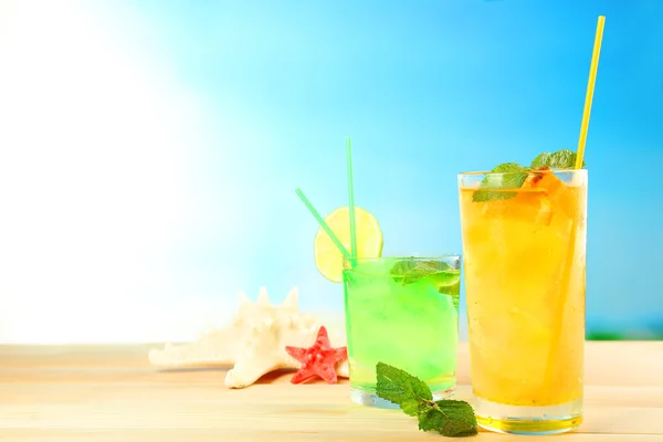 Uppfriskande cocktail på träbord på blå bakgrund — Stockfoto
