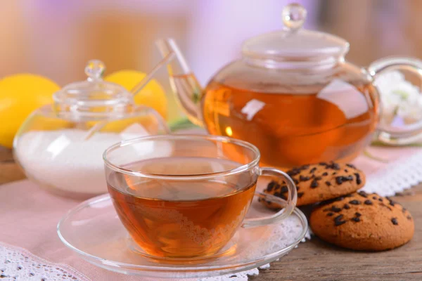 Theepot en kopje thee op tafel op lichte achtergrond — Stockfoto