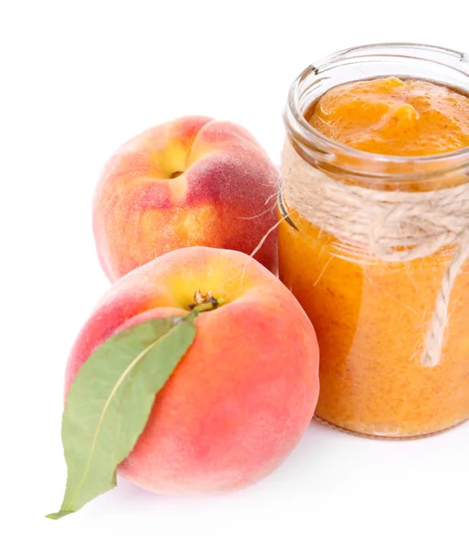 Tasty peach jam with fresh peaches, isolated on white — Stock Photo, Image