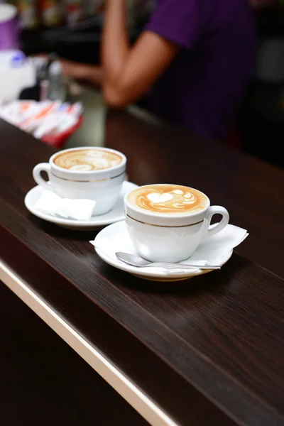 Tazas de café con dibujo lindo en la cafetería — Foto de Stock