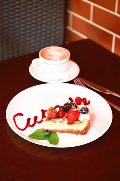 Cup of coffee and tasty cupcake on table in cafe — Stock Photo, Image