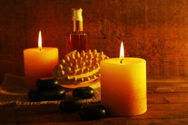 Spa taşlar, yağ ve ahşap zemin üzerine mumlar