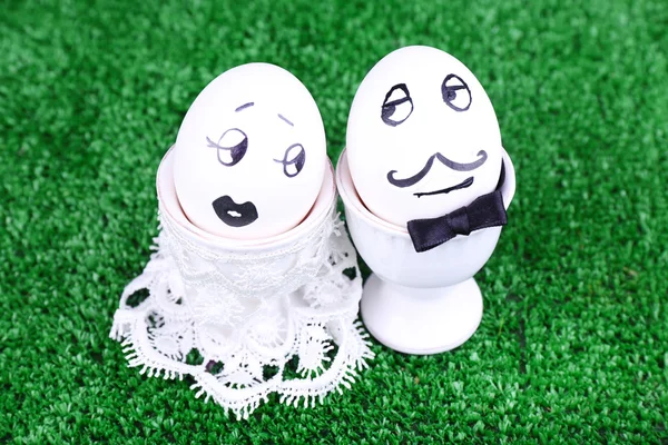 Bride and bridegroom eggs in egg cups on green background — Stock Photo, Image
