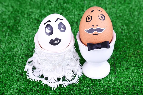 Bride and bridegroom eggs in egg cups on green background — Stock Photo, Image