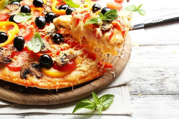 Läcker pizza serveras på träbord — Stockfoto