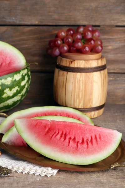 Composizione di anguria matura, frutta e botte di legno su fondo rustico in legno — Foto Stock