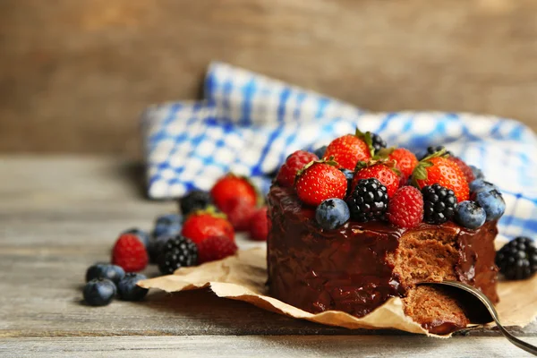 Tasty chocolate cake with different berries on wooden table — Stock Photo, Image