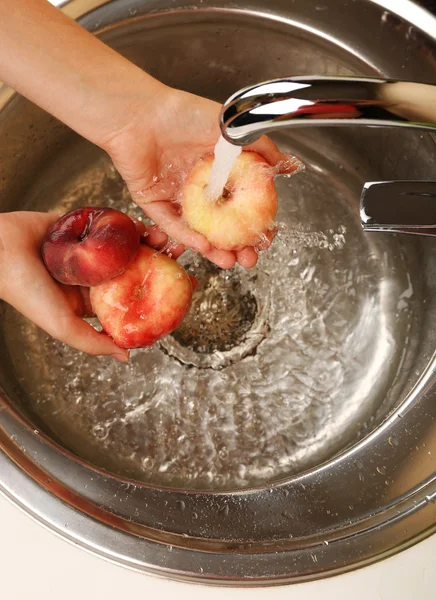 Woman's hands washing peaches in sink — Stock Photo, Image