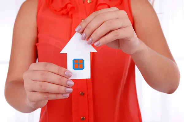 Woman hands holding paper house on light background — Stock Photo, Image