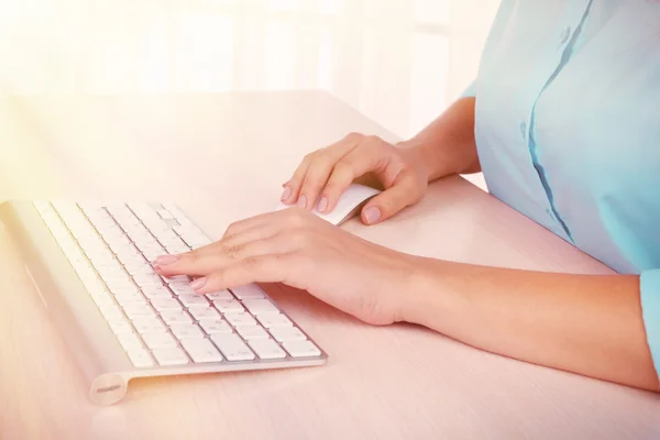 Mãos femininas digitando no teclado no fundo claro — Fotografia de Stock