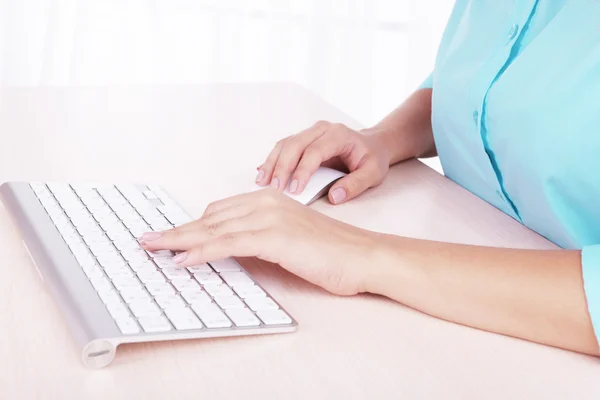 Vrouwelijke handen te typen op het toetsenbord op lichte achtergrond — Stockfoto